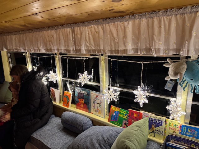 books with decorative lights in windows of bus